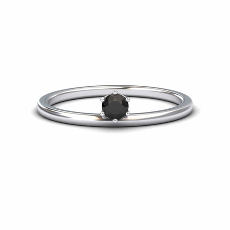 The Black Diamond Solitaire Petite Ring - Faria features a single round black diamond held by six prongs in a simple silver band, shown against a plain white background.