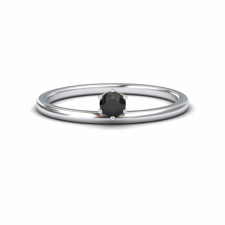 The Black Diamond Solitaire Petite Ring - Faria features a single round black diamond held by six prongs in a simple silver band, shown against a plain white background.