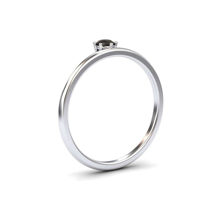 The Black Diamond Solitaire Petite Ring - Faria features a simple silver band with a single round black diamond in a minimalist prong setting, shown against a plain white background.