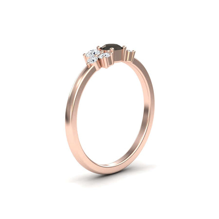 The Black & White Diamond Cluster Ring - Liana features a delicate rose gold band with a black central stone and two smaller white diamonds, shown on a white background.