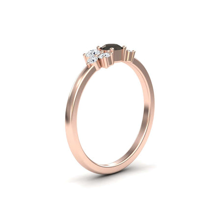 The Black & White Diamond Cluster Ring - Liana features a delicate rose gold band with a black central stone and two smaller white diamonds, shown on a white background.