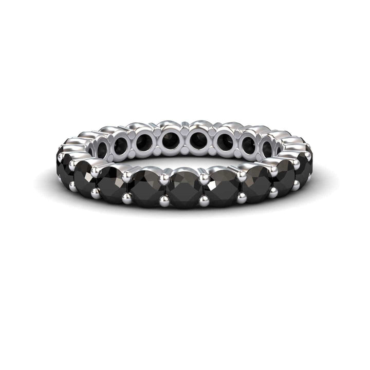 The Black Diamond Prong-Set Eternity Band - Mahira features round black stones set all around its silver band, shown against a white background.