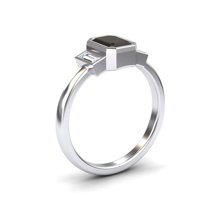 The Black & White Diamond Three-Stone Art Deco Ring - Ivy features a rectangular black gemstone center with two smaller clear stones on a polished silver band, displayed against a white background.