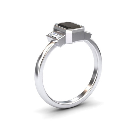 The Black & White Diamond Three-Stone Art Deco Ring - Ivy features a rectangular black gemstone center with two smaller clear stones on a polished silver band, displayed against a white background.