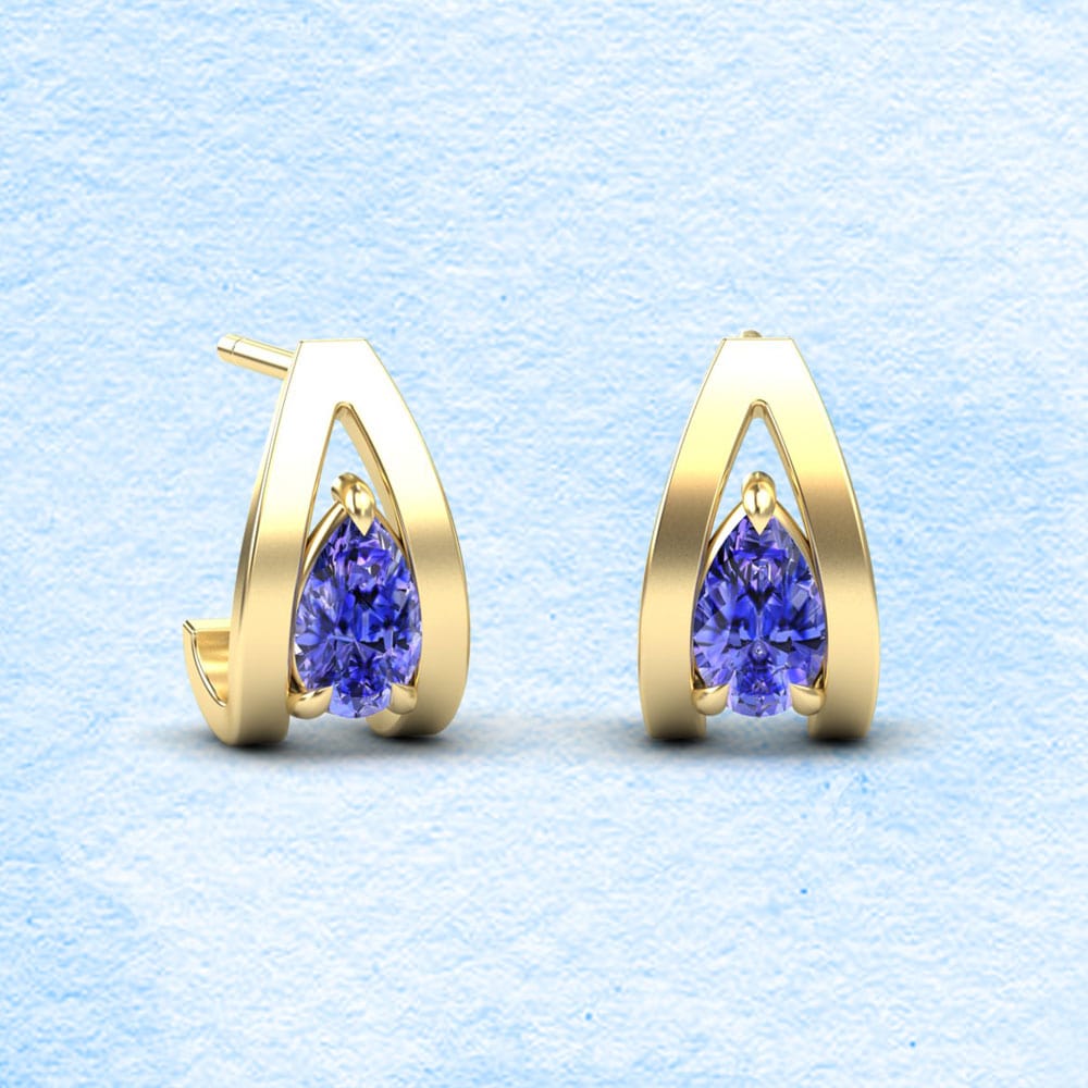 Gold hoop earrings with purple tanzanite gemstones on a light blue textured background