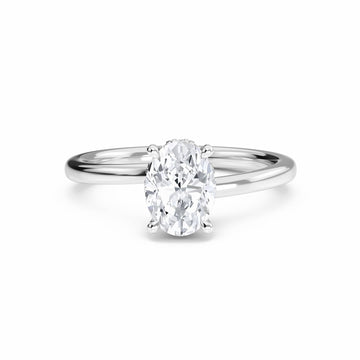 The Lyric White Diamond Hidden Halo Solitaire Engagement Ring in 18K white gold features a 0.200 carat oval diamond, E color, VS1 clarity, set in a four-prong setting and displayed on a white background.
