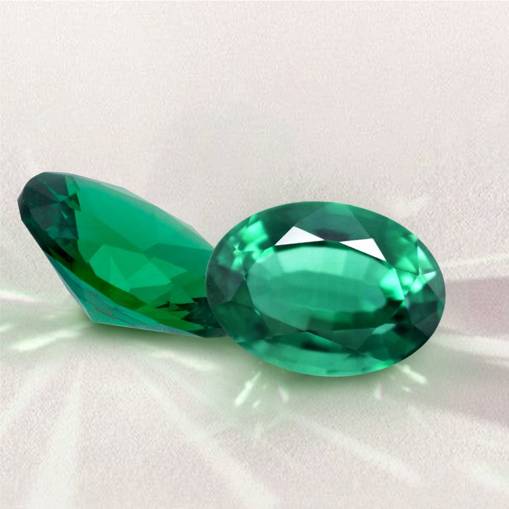 Two green gemstones on a white background