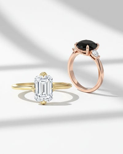 Two diamond rings, one gold and one rose gold, on a white background